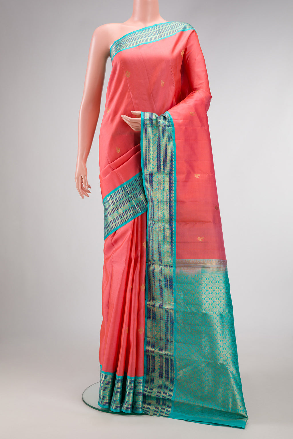 Coral Kanchipuram Silk Saree with Zari Butta on the body and Zari Border.  displayed on a mannequin