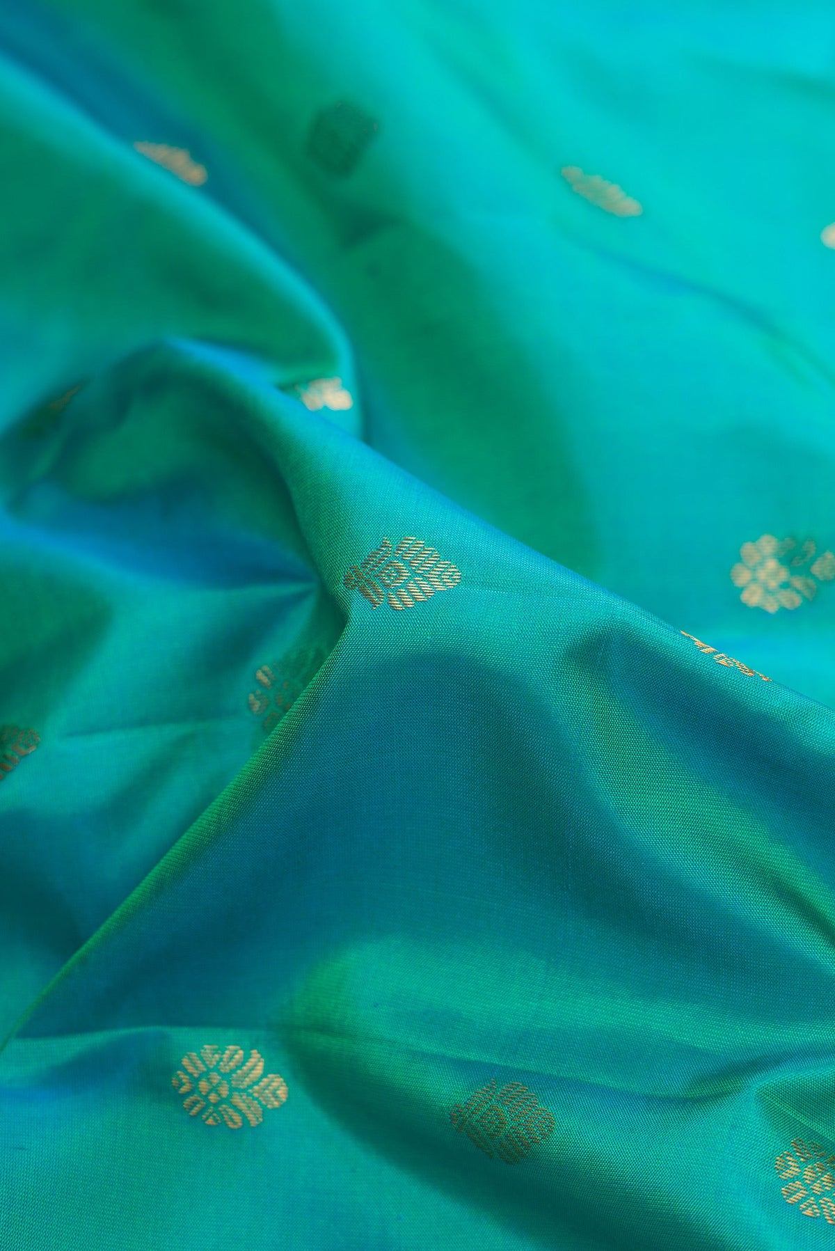 Close up of Green Dual Tone Gadwal Silk Saree with Zari Butta on the body and Zari Border.  displaying folds