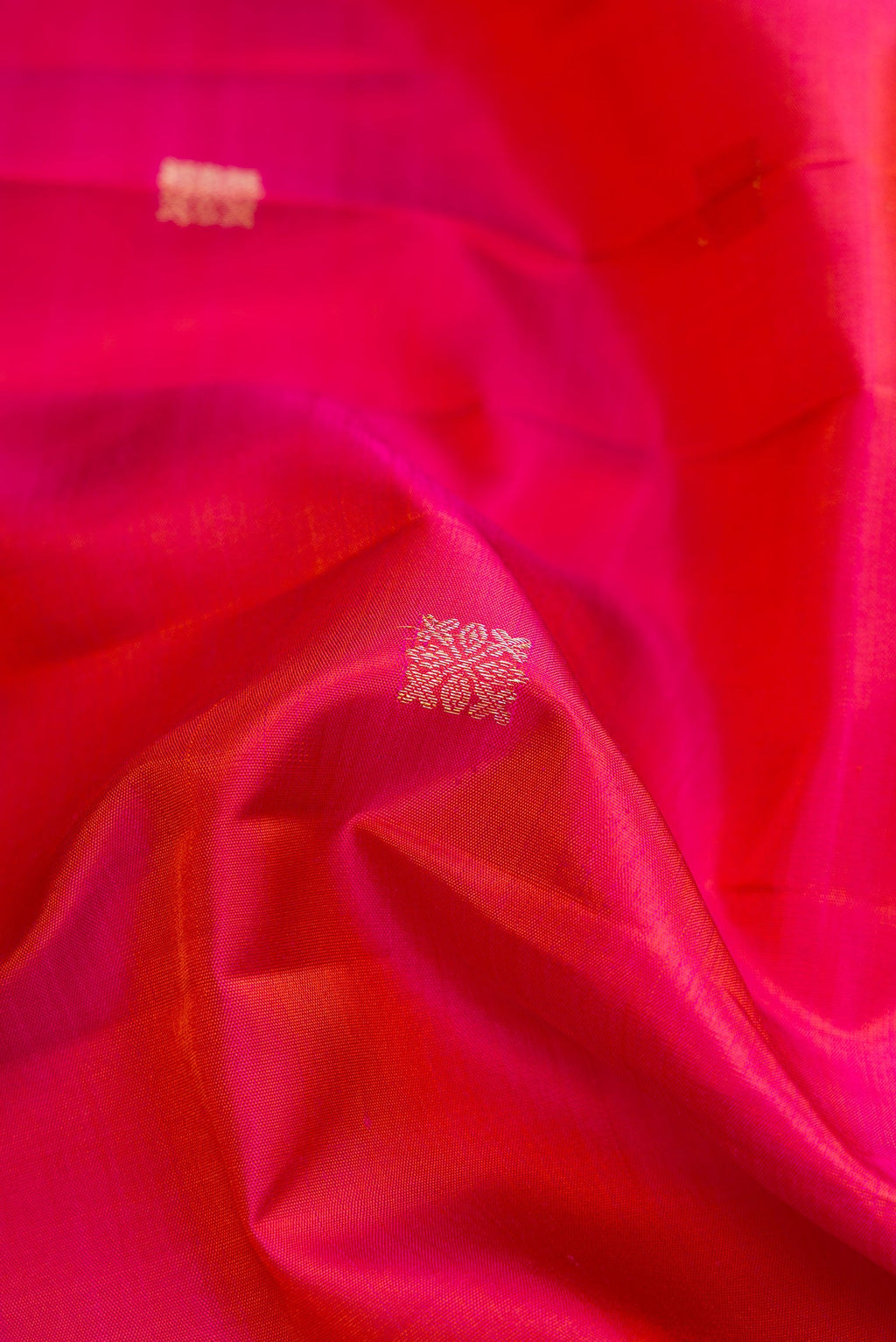 Close up of Coral Dual Tone Kanjivaram Silk Saree with Zari Butta on the body and Fancy Border.  displaying folds
