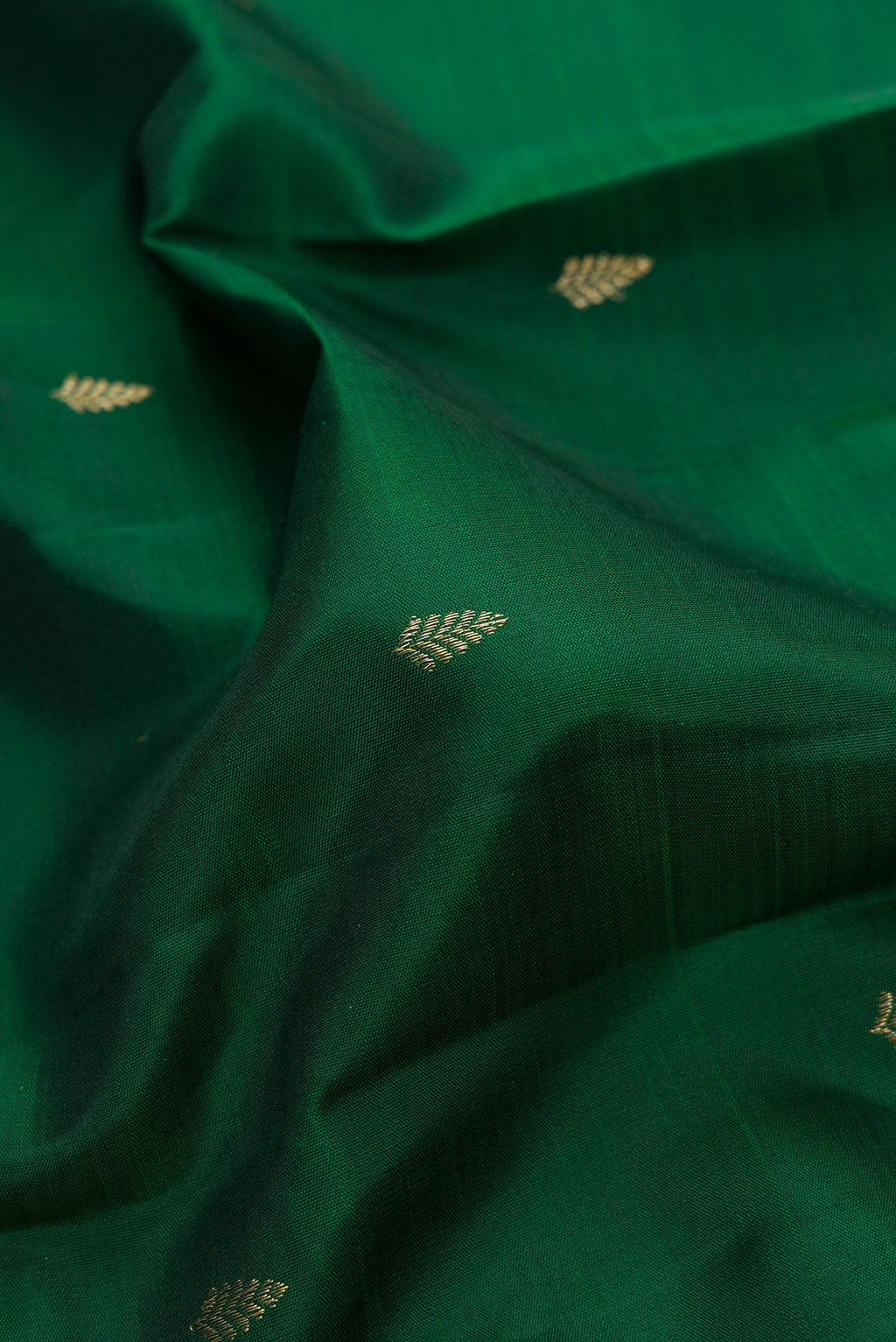 Close up of Bottle Green Dual Tone Kanjivaram Silk Saree with Zari Butta on the body and Fancy Border.  displaying folds