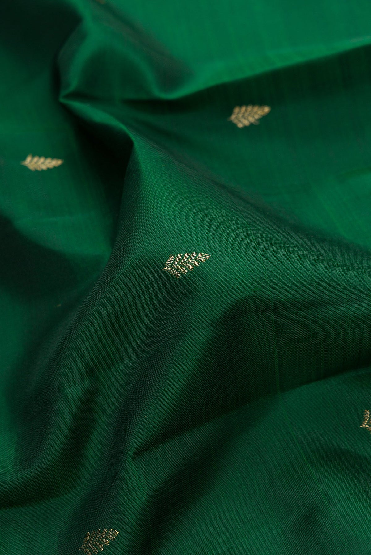 Close up of Bottle Green Dual Tone Kanjivaram Silk Saree with Zari Butta on the body and Fancy Border.  displaying folds