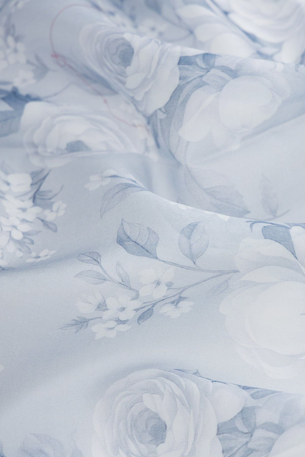Close up of Grey Dual Tone Organza Silk Saree with Printed design on the body and Plain Border.  displaying folds