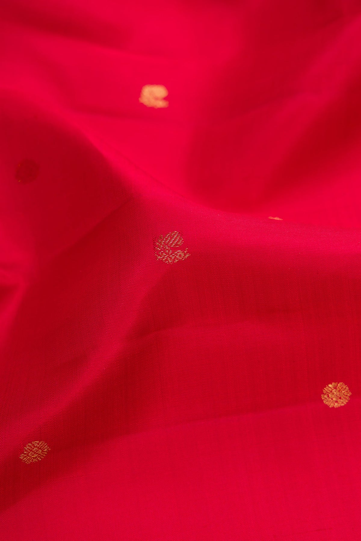 Close up of Red Dual Tone Kanjivaram Silk Saree with Zari Butta on the body and Zari Border.  displaying folds