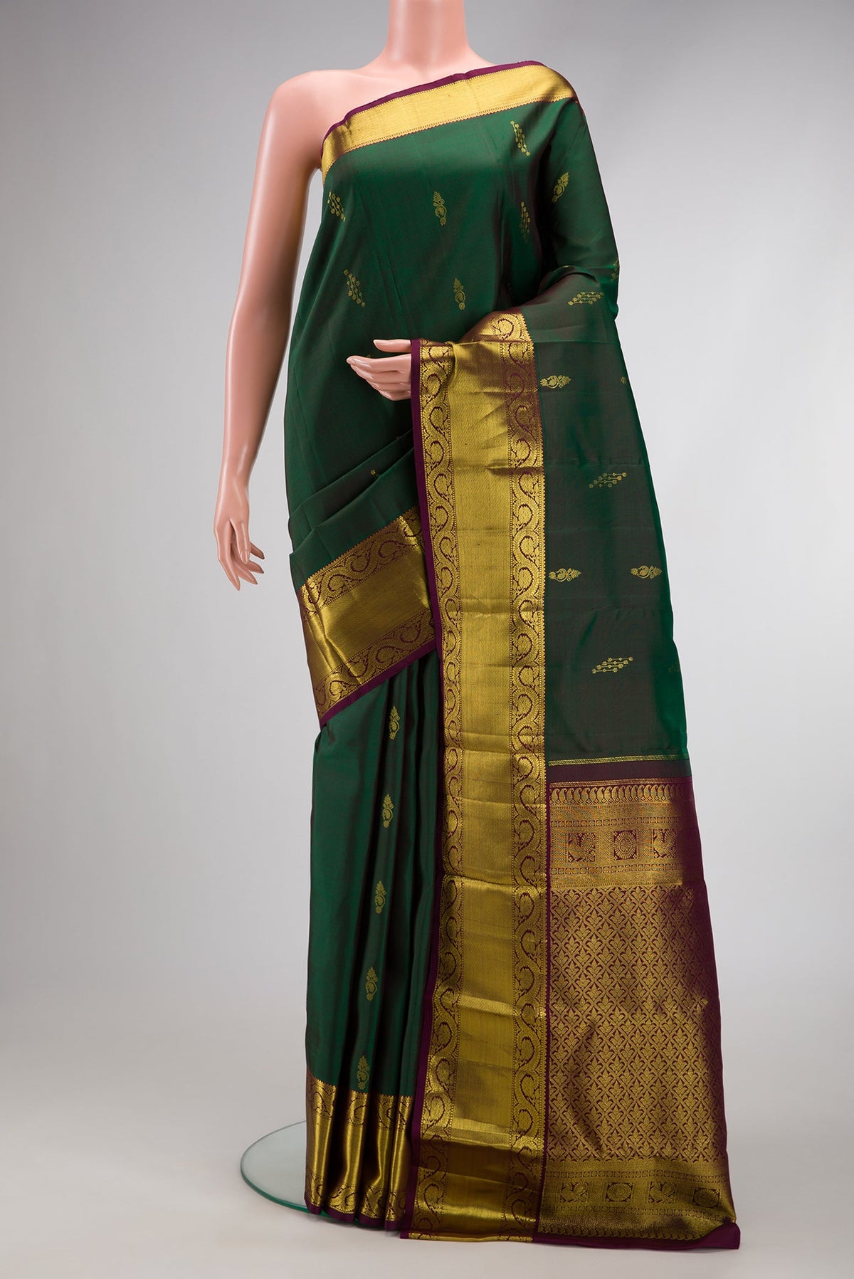 Bottle Green Dual Tone Kanjivaram Silk Saree with Zari Butta on the body and Zari Border.  displayed on a mannequin