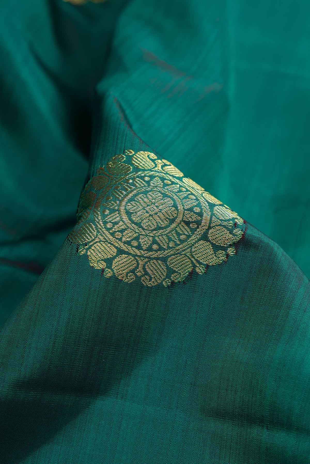 Close up of Bottle Green Dual Tone Kanjivaram Silk Saree with Zari Butta on the body and Zari Border.  displaying folds
