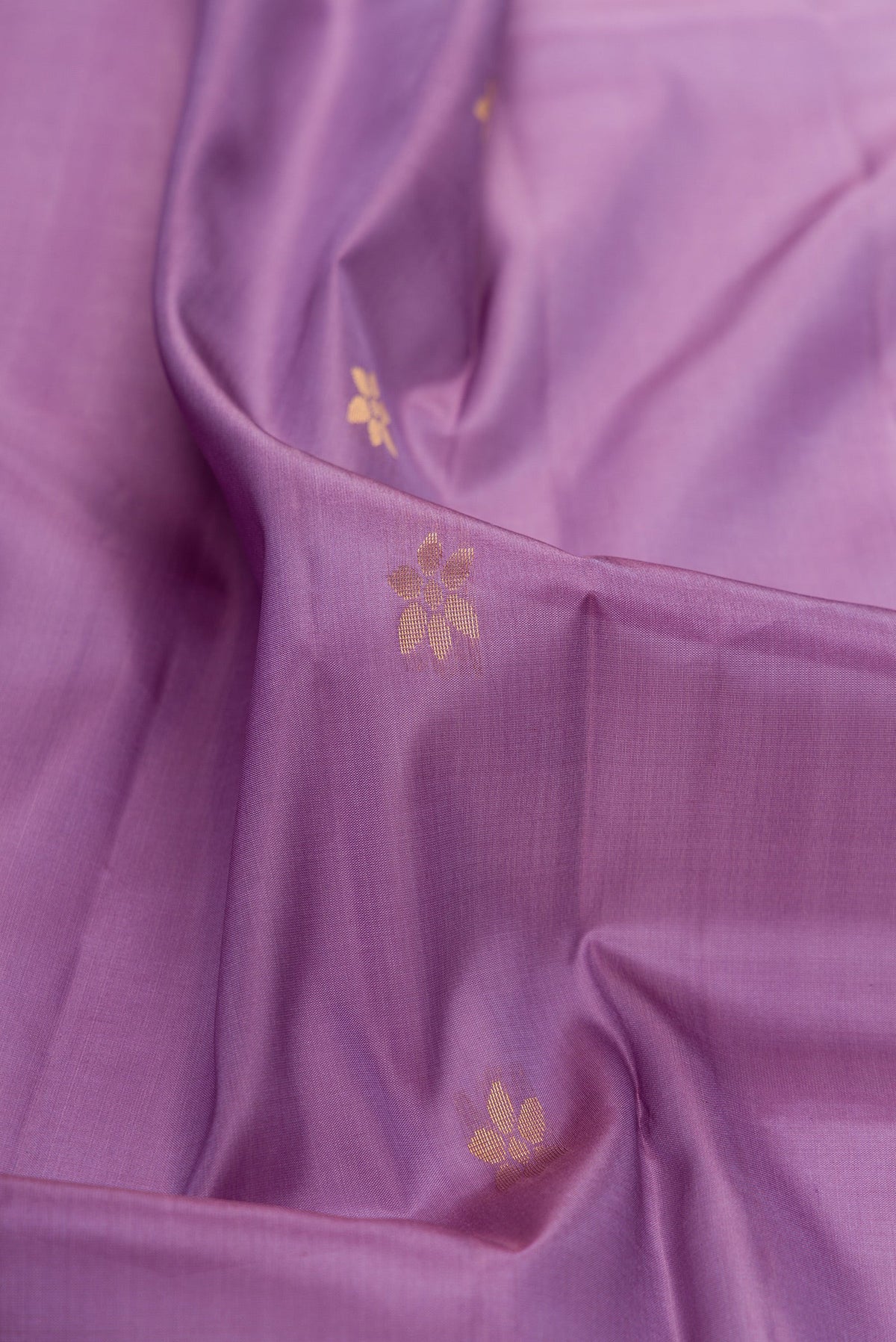 Close up of Lavender Soft Silk Saree with Zari Butta on the body and Fancy Border.  displaying folds