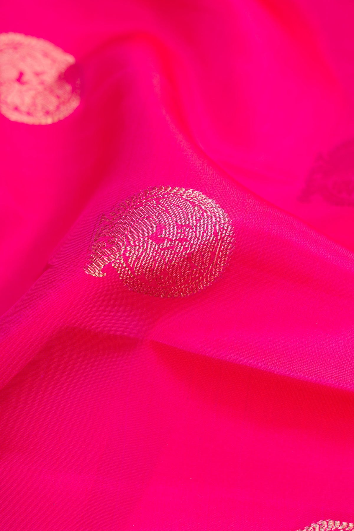 Close up of Pink Dual Tone Kanjivaram Silk Saree with Zari Butta on the body and Zari Border.  displaying folds