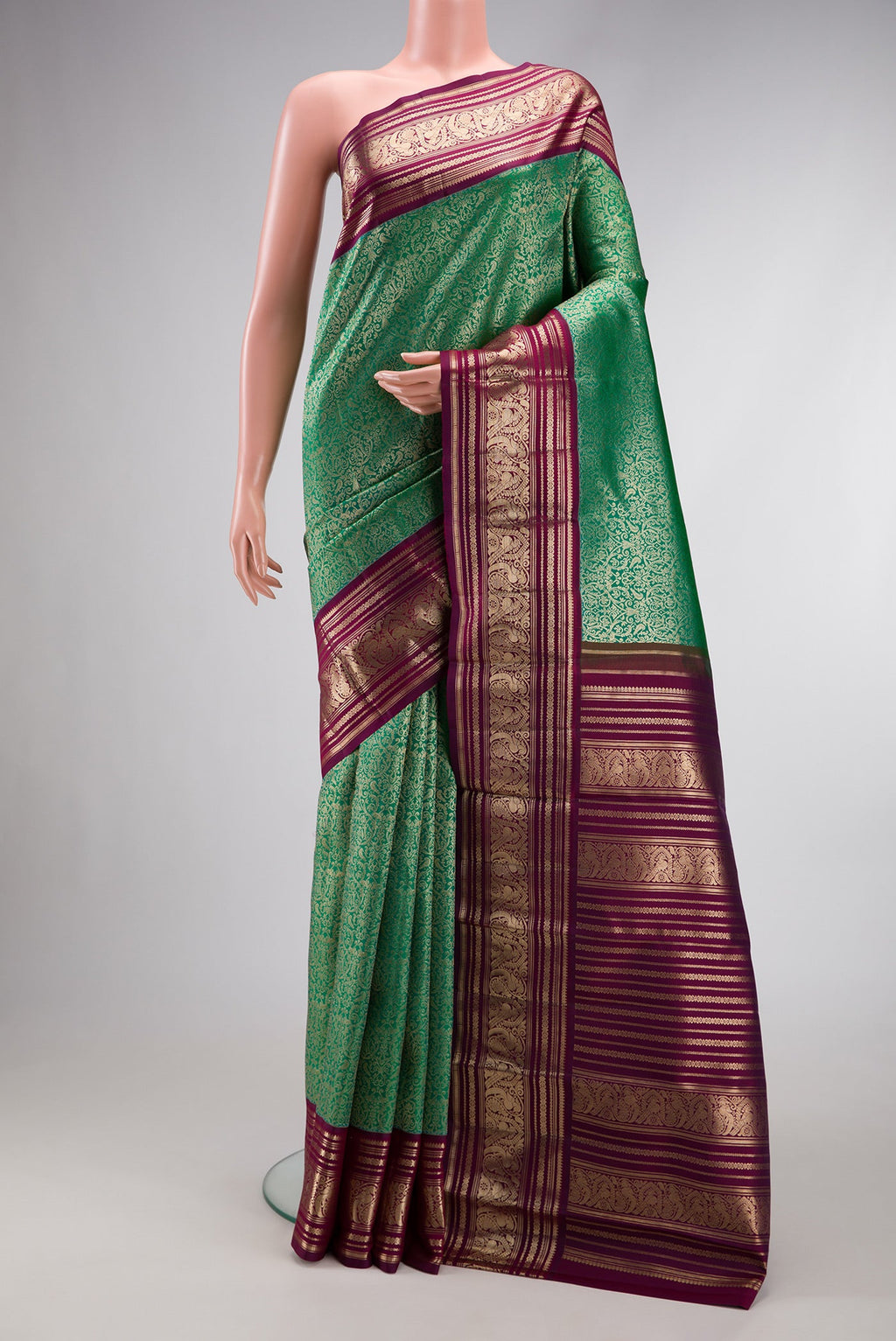 Sea Green Dual Tone Kanchipuram Silk Saree with Zari Brocade on the body and Zari Border.  displayed on a mannequin