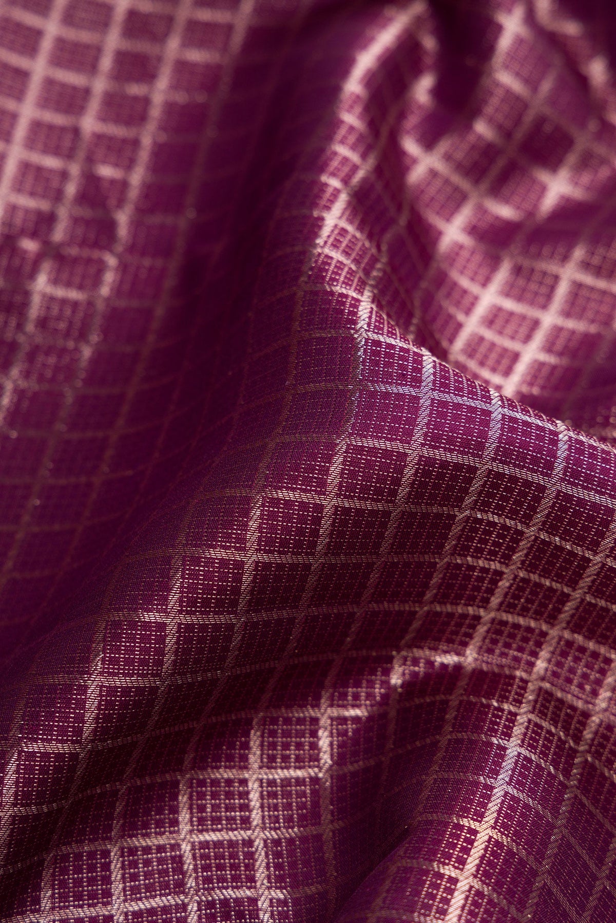 Close up of Burgundy Dual Tone Kanchipuram Silk Saree with Zari Brocade on the body and Zari Border.  displaying folds