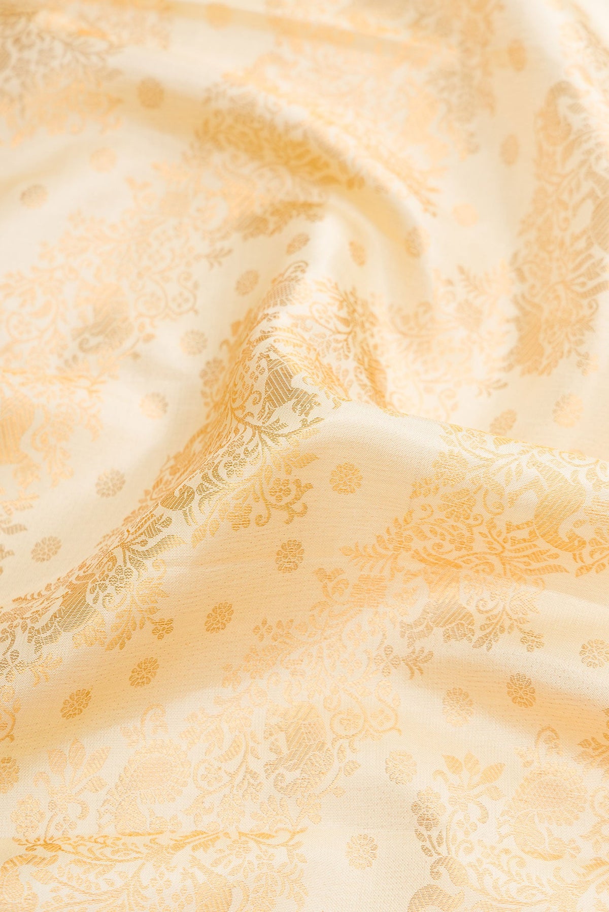 Close up of Off White Dual Tone Kanjivaram Silk Saree with Zari Brocade on the body and Zari Border.  displaying folds