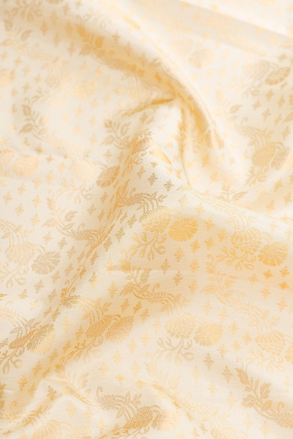 Close up of Off White Dual Tone Kanjivaram Silk Saree with Zari Brocade on the body and Zari Border.  displaying folds