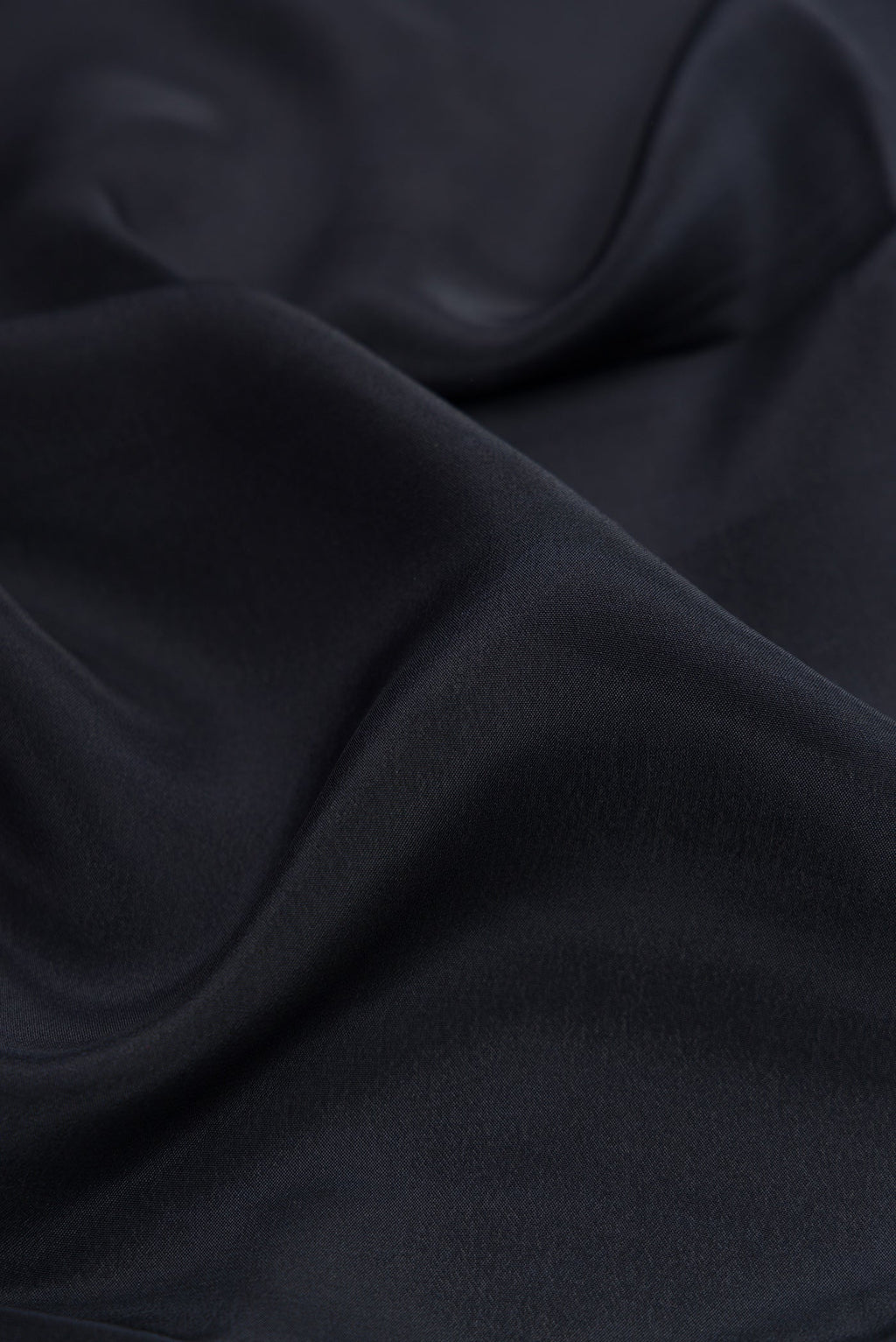 Close up of Black Crepe Saree with Plain Body and Printed Border.  displaying folds