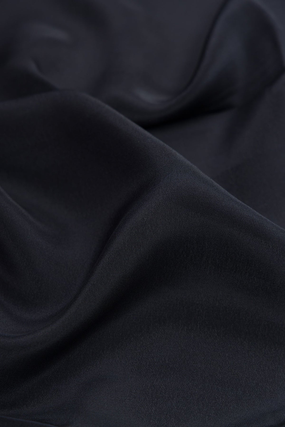 Close up of Black Crepe Saree with Plain Body and Printed Border.  displaying folds