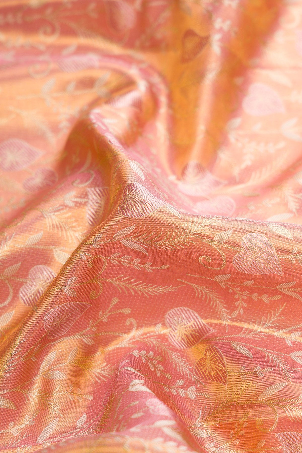 Close up of Rose Gold Dual Tone Kanjivaram Tissue Silk Saree with Zari Brocade on the body and Fancy Border.  displaying folds