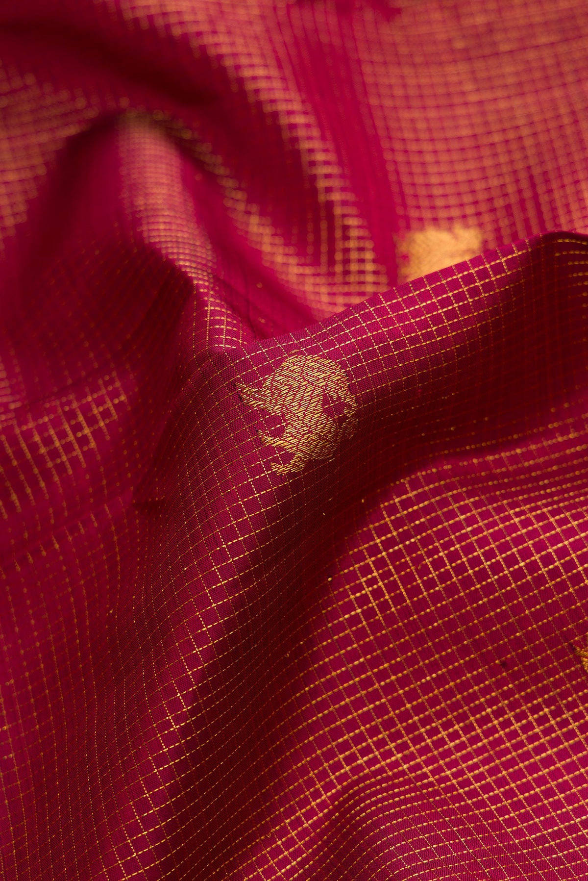 Close up of Maroon Kanjivaram Silk Saree with Zari Butta on the body and Zari Border.  displaying folds