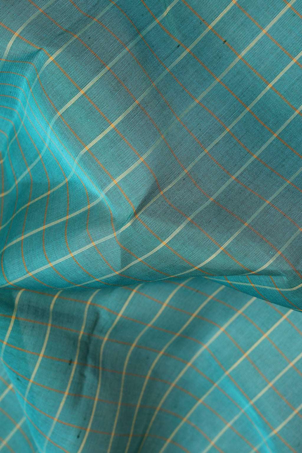 Close up of Green Kanchi Cotton Saree with Checked design on the body and Plain Border.  displaying folds