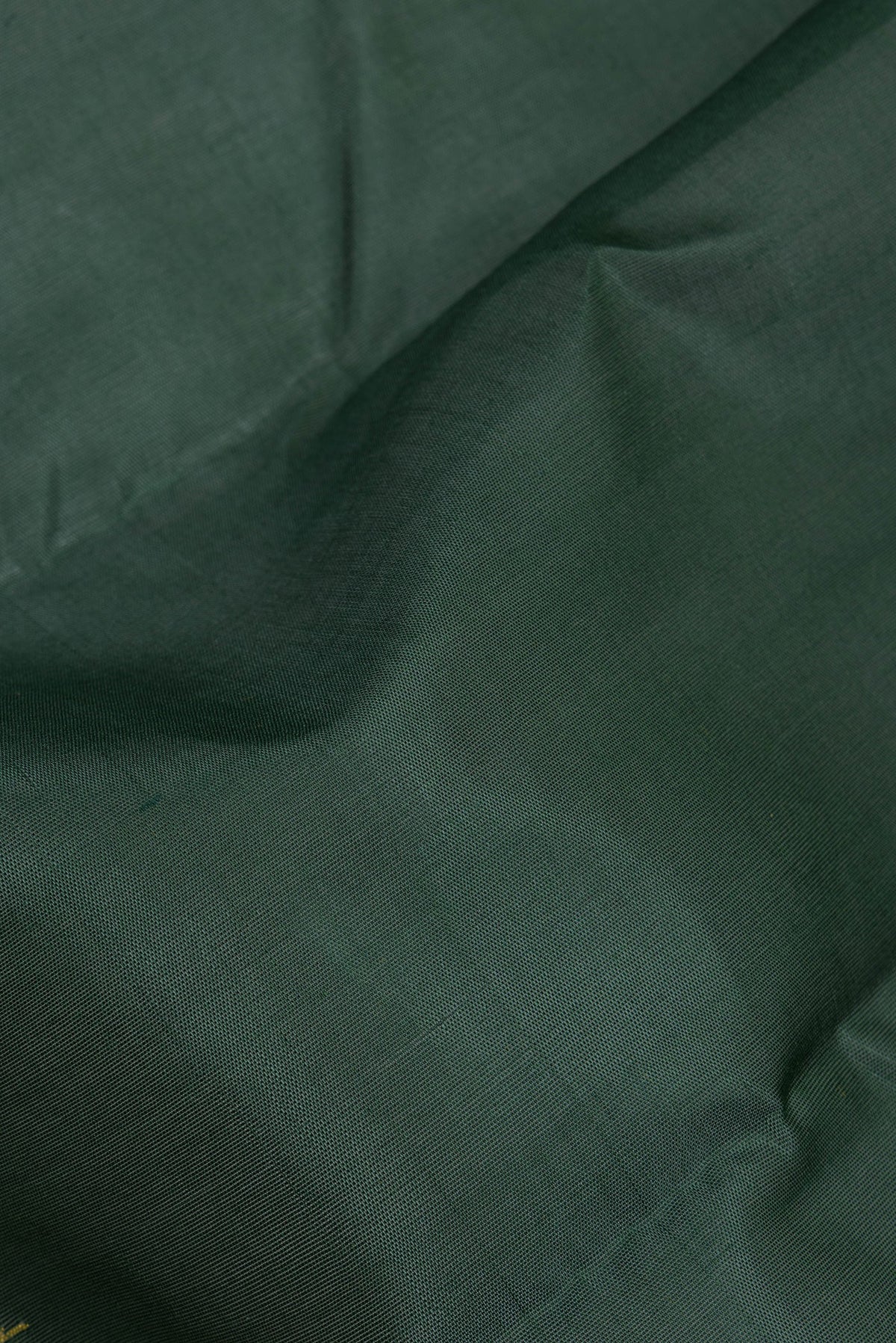 Close up of Bottle Green Kanchi Cotton Saree with Plain Body and Temple Border.  displaying folds