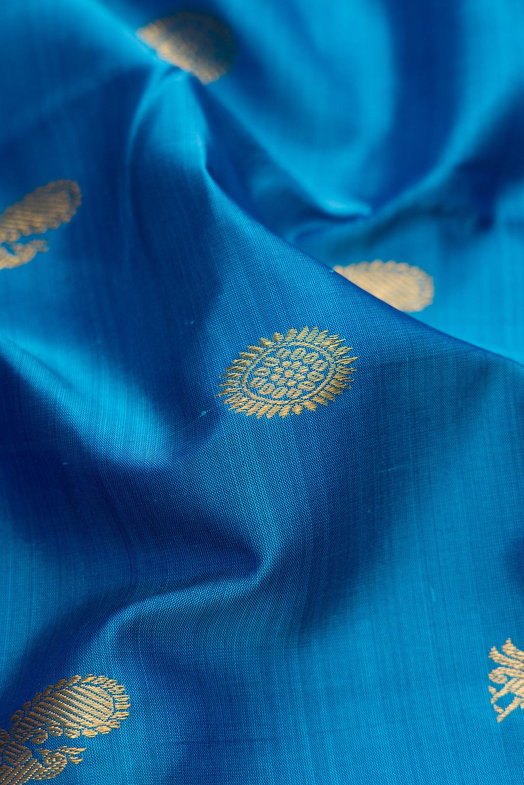 Close up of Pure Silk Pure Zari Peacock Blue Dual Tone Kanchipuram Nine Yards Saree with Zari Butta on the body and Zari Border.  displaying folds