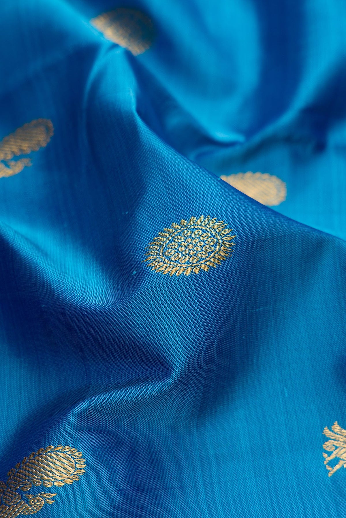 Close up of Pure Silk Pure Zari Peacock Blue Dual Tone Kanchipuram Nine Yards Saree with Zari Butta on the body and Zari Border.  displaying folds