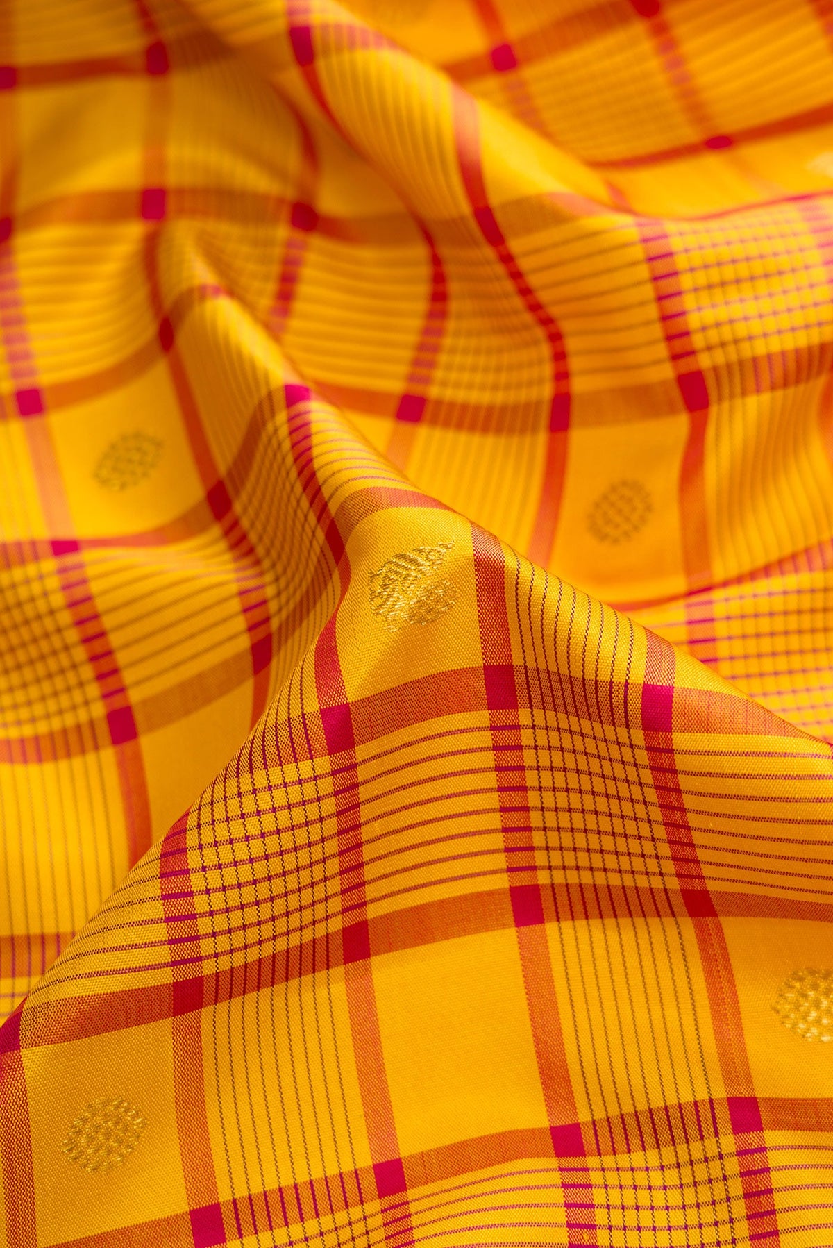 Close up of Pure Silk Pure Zari Mustard Dual Tone Kanjivaram Saree with Checked design on the body and Zari Border.  displaying folds