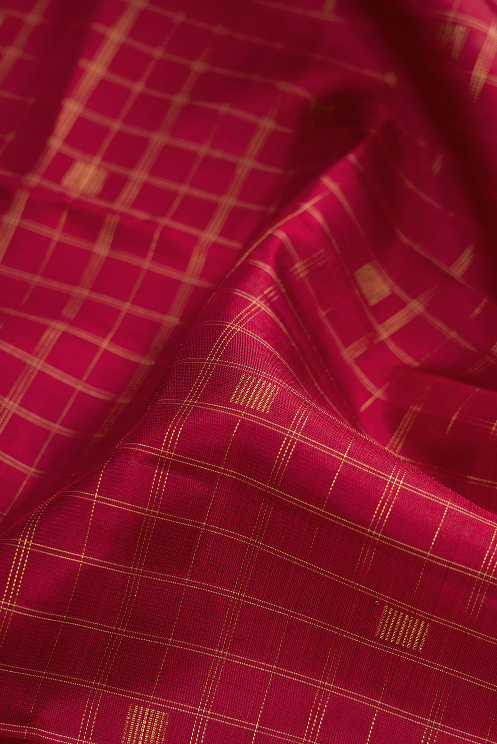 Close up of Pure Silk Pure Zari Maroon Dual Tone Kanchipuram Saree with Checked design on the body and Without Border.  displaying folds