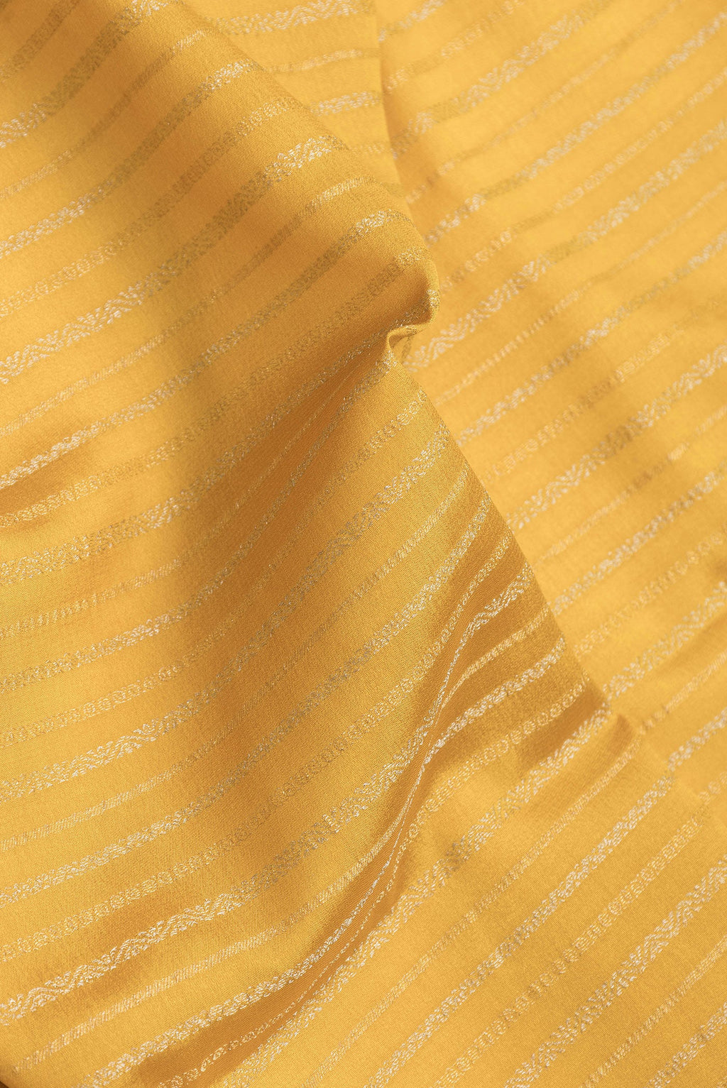 Close up of Mustard Dual Tone Banarasi Georgette Saree with Stripes on the body and Zari Border.  displaying folds