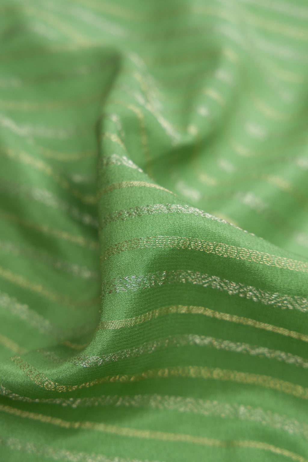 Close up of Pista Green Mysore Crepe Saree with Stripes on the body and Zari Border.  displaying folds