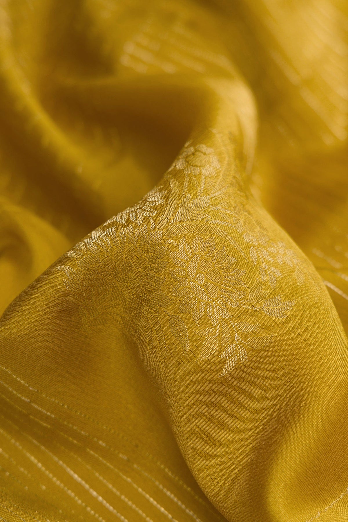 Close up of Mehandi Green Dual Tone Mysore Crepe Saree with Zari Butta on the body and Zari Border.  displaying folds
