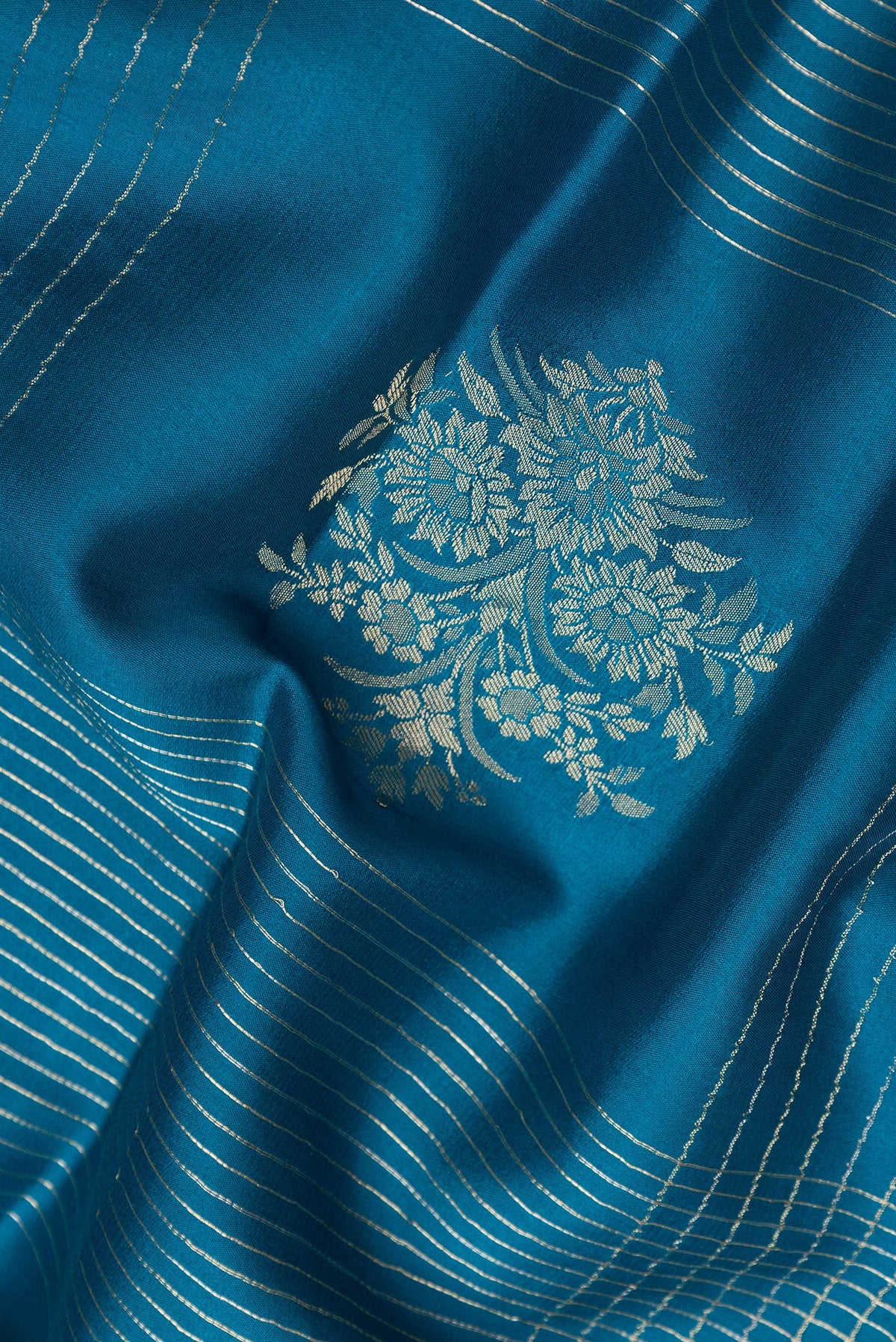 Close up of Peacock Blue Dual Tone Banarasi Georgette Saree with Checked design on the body and Zari And Thread Border.  displaying folds