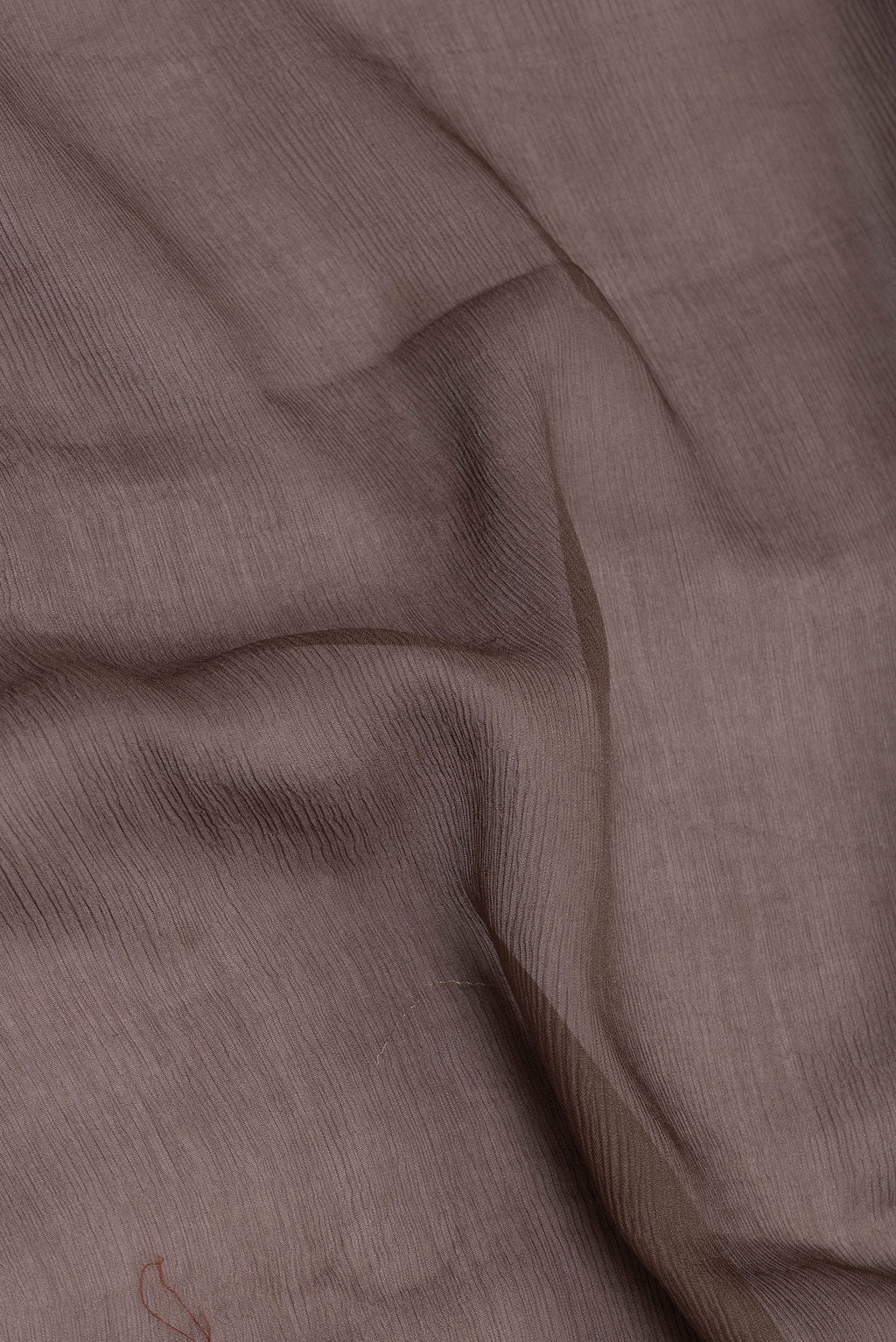 Close up of Brown Mysore Chiffon Saree with Plain Body and Zari Border.  displaying folds
