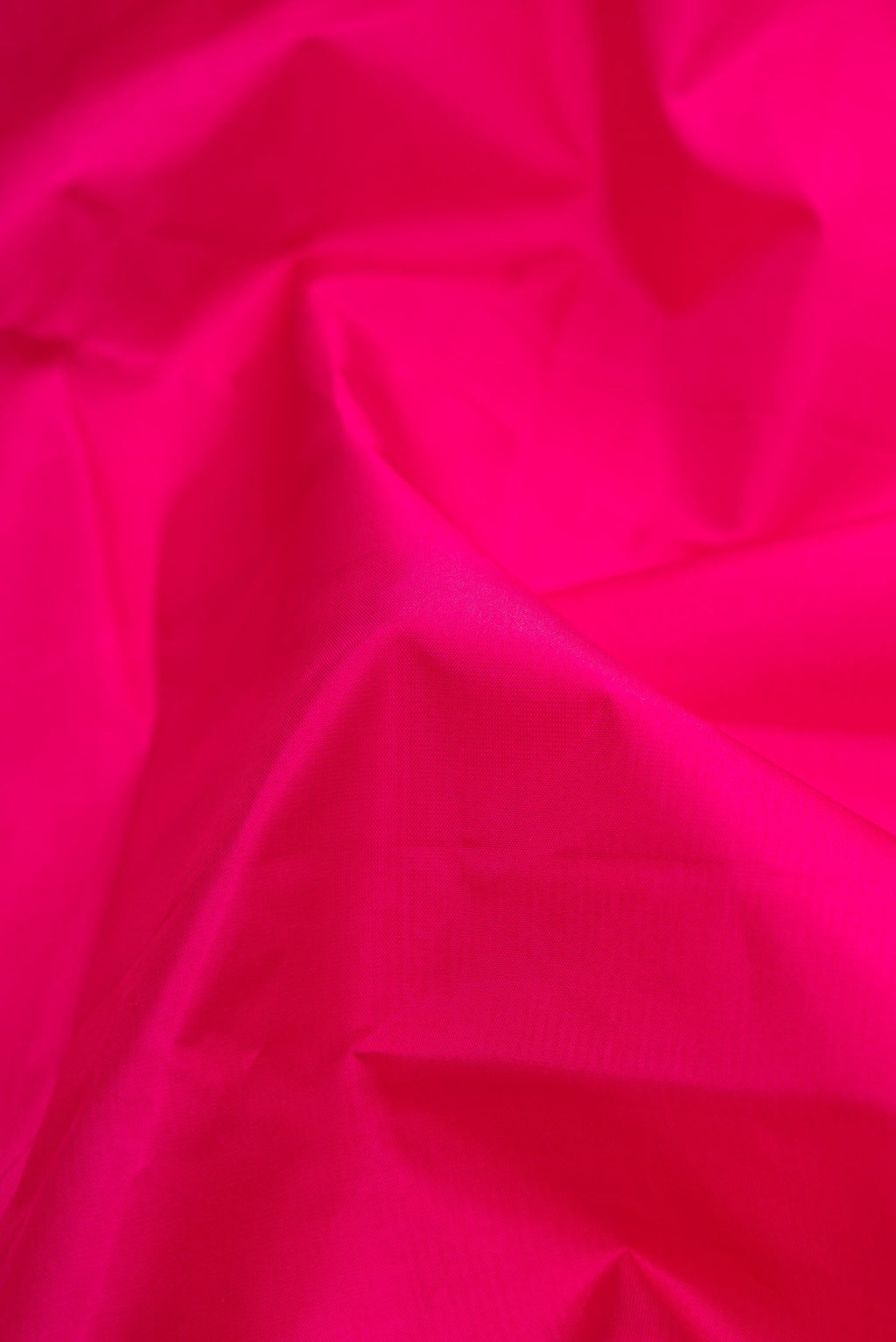 Close up of Magenta Dual Tone Kanjivaram Silk Saree with Plain Body and Zari Border.  displaying folds