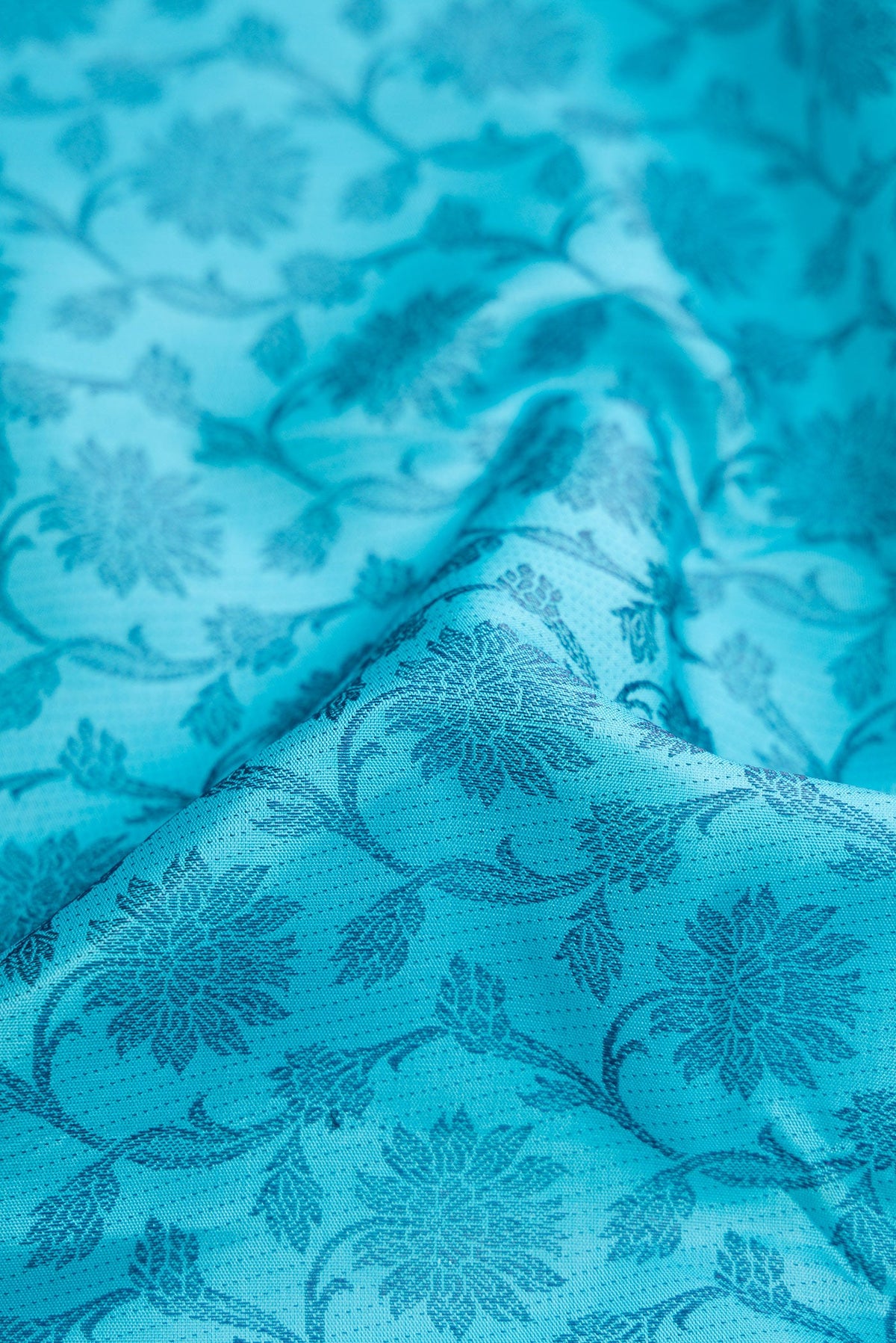 Close up of Sky Blue Dual Tone Kanjivaram Silk Saree with Zari Butta on the body and Fancy Border.  displaying folds