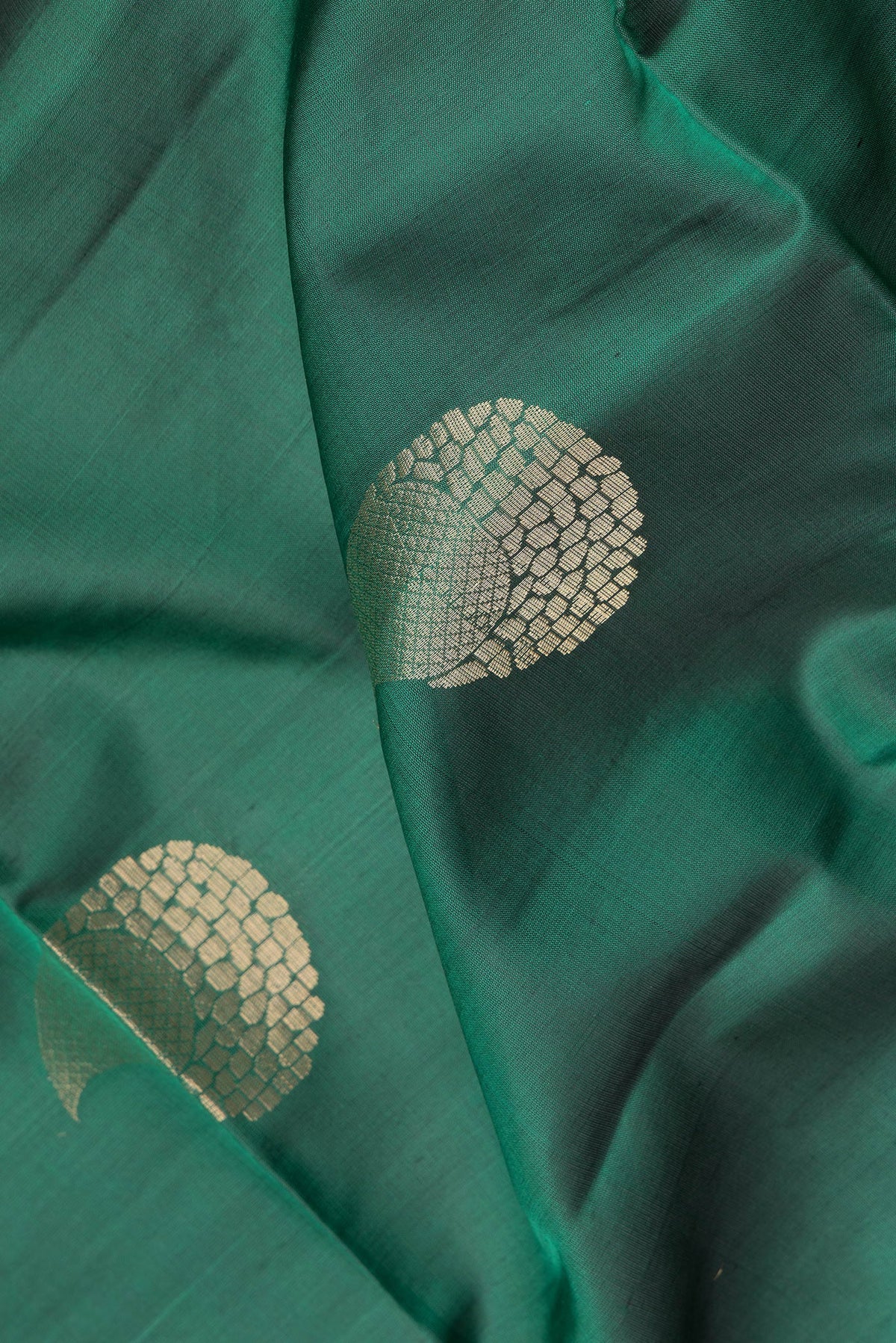 Close up of Green Soft Silk Saree with Zari Butta on the body and Zari Border.  displaying folds