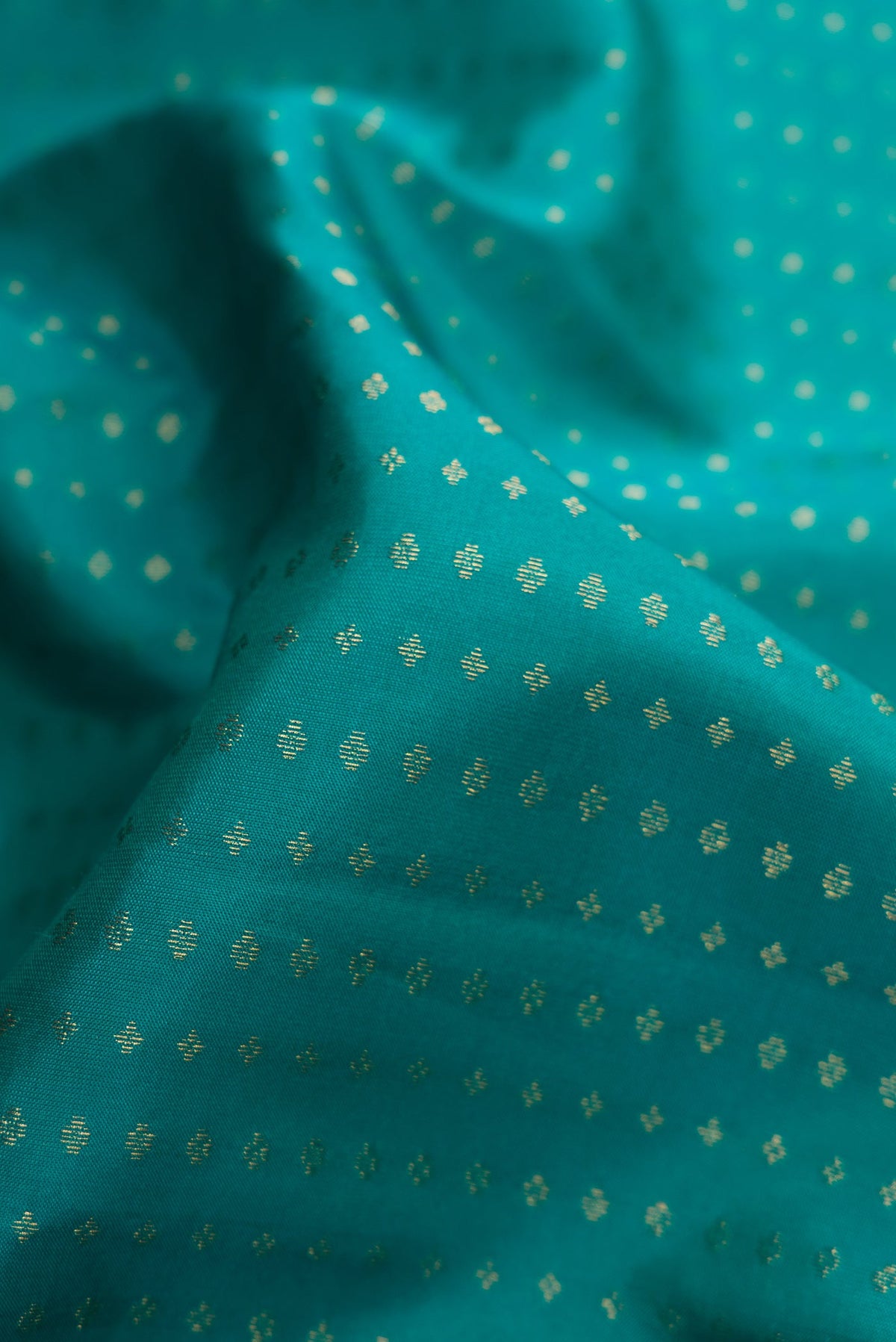 Close up of Green Dual Tone Kanchipuram Silk Saree with Stripes on the body and Zari Border.  displaying folds