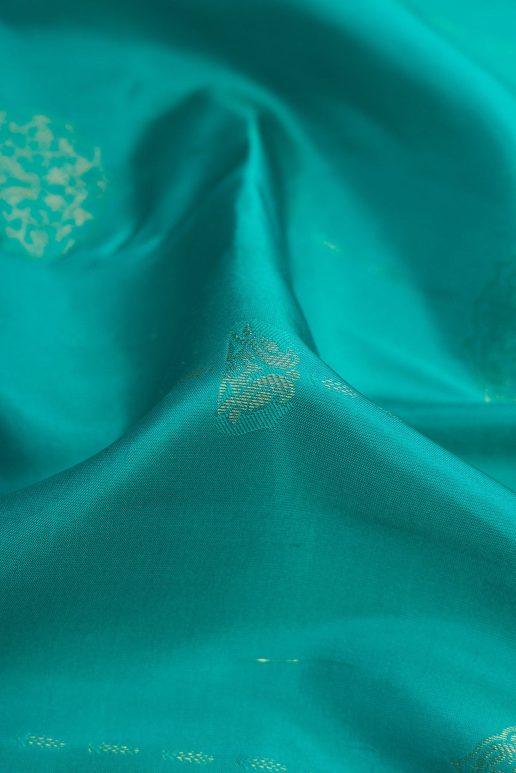 Close up of Sky Blue Kanchipuram Silk Saree with Zari Butta on the body and Zari Border.  displaying folds