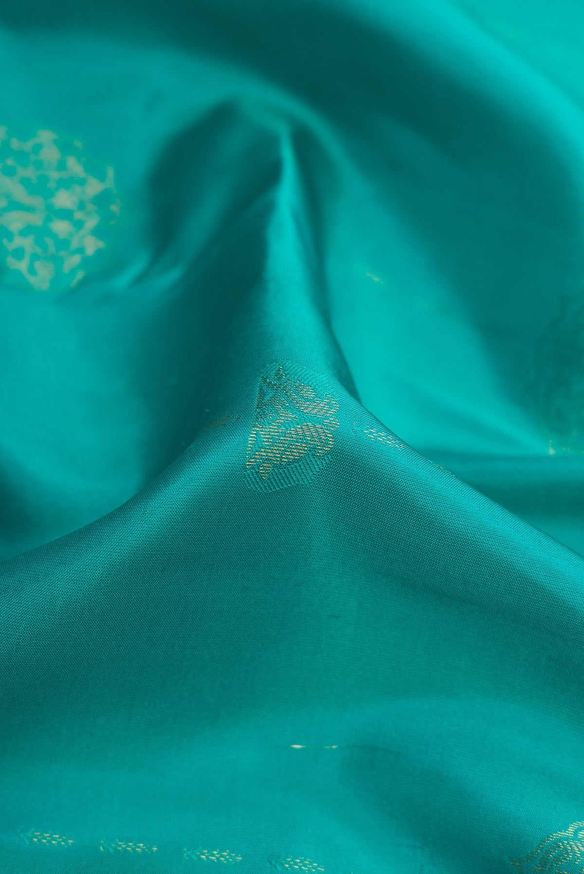 Close up of Sky Blue Kanchipuram Silk Saree with Zari Butta on the body and Zari Border.  displaying folds