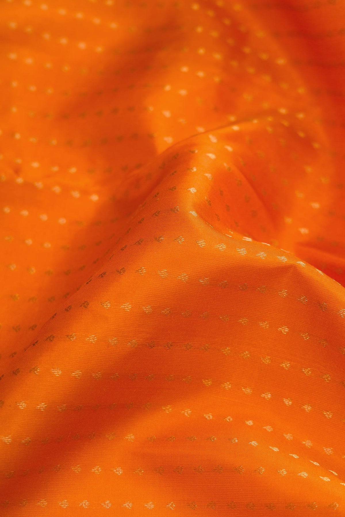 Close up of Orange Dual Tone Kanchipuram Silk Saree with Stripes on the body and Fancy Border.  displaying folds