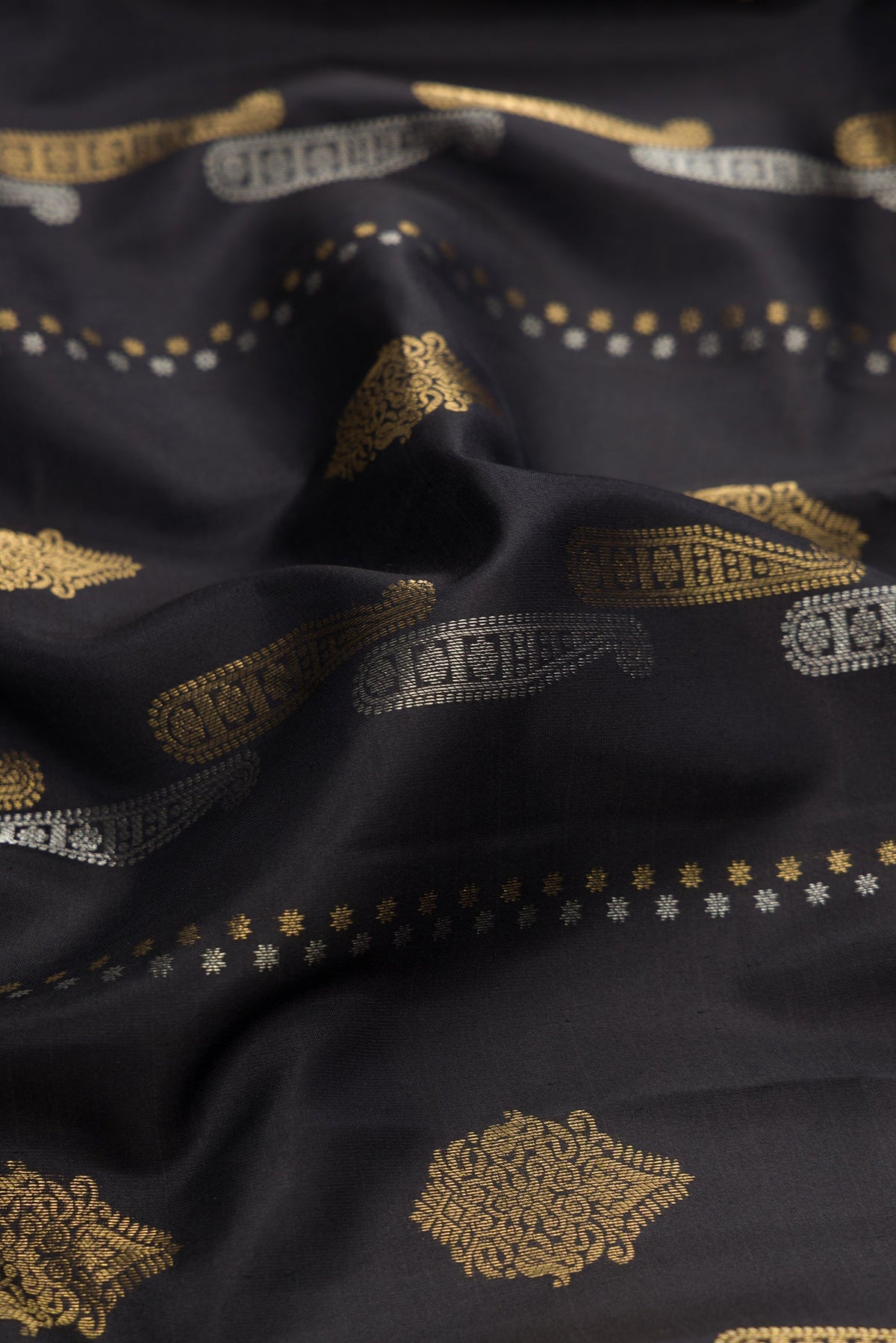 Close up of Black Dual Tone Kanjivaram Silk Saree with Zari Butta on the body and Zari Border.  displaying folds