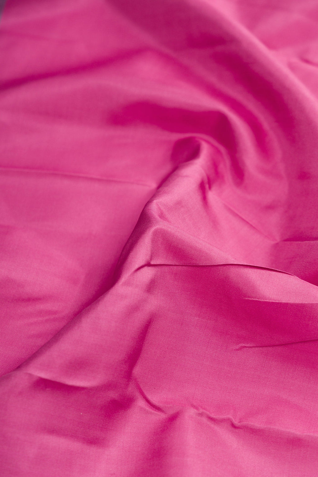 Close up of Pink Dual Tone Kanchipuram Silk Saree with Plain Body and Fancy Border.  displaying folds