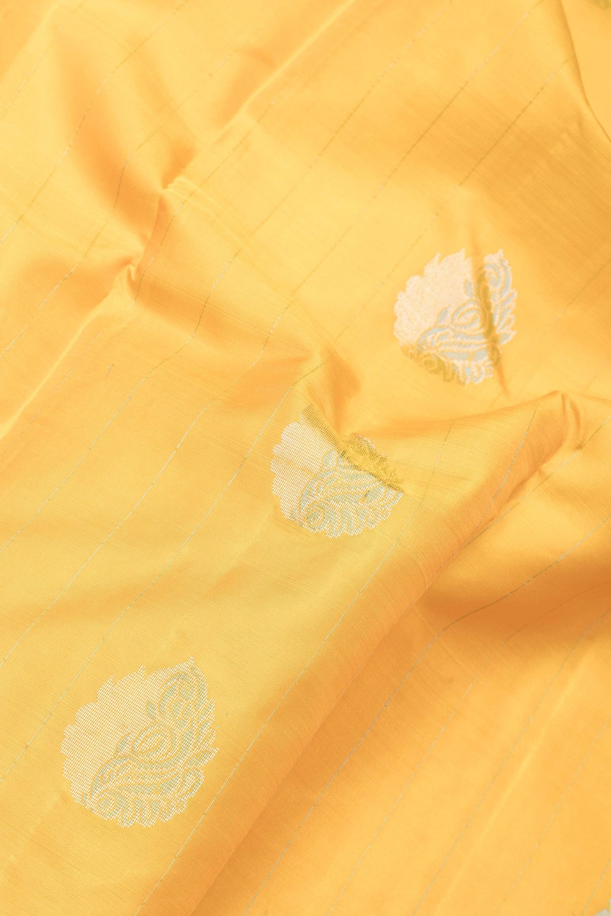 Close up of Yellow Dual Tone Kanchipuram Silk Saree with Stripes on the body and Fancy Border.  displaying folds