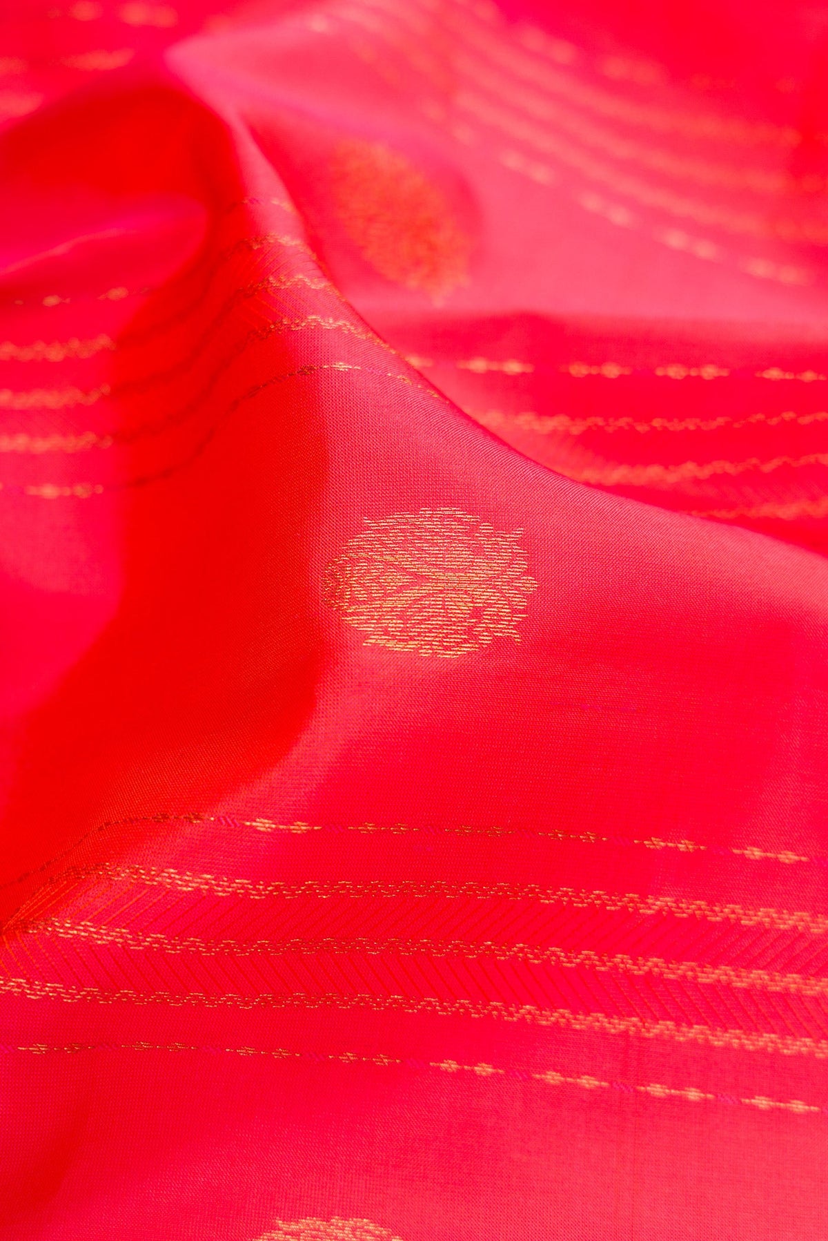 Close up of Coral Dual Tone Kanchipuram Silk Saree with Jacquard With Zari Butta on the body and Zari Border.  displaying folds
