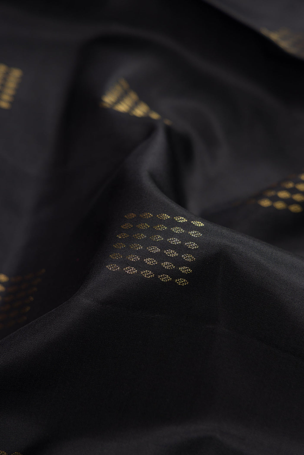 Close up of Black Dual Tone Soft Silk Saree with Zari Butta on the body and Fancy Border.  displaying folds