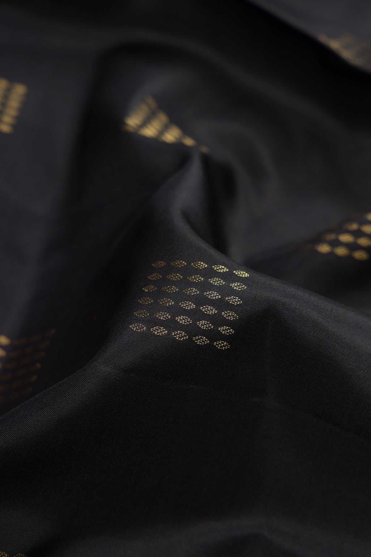 Close up of Black Dual Tone Soft Silk Saree with Zari Butta on the body and Fancy Border.  displaying folds