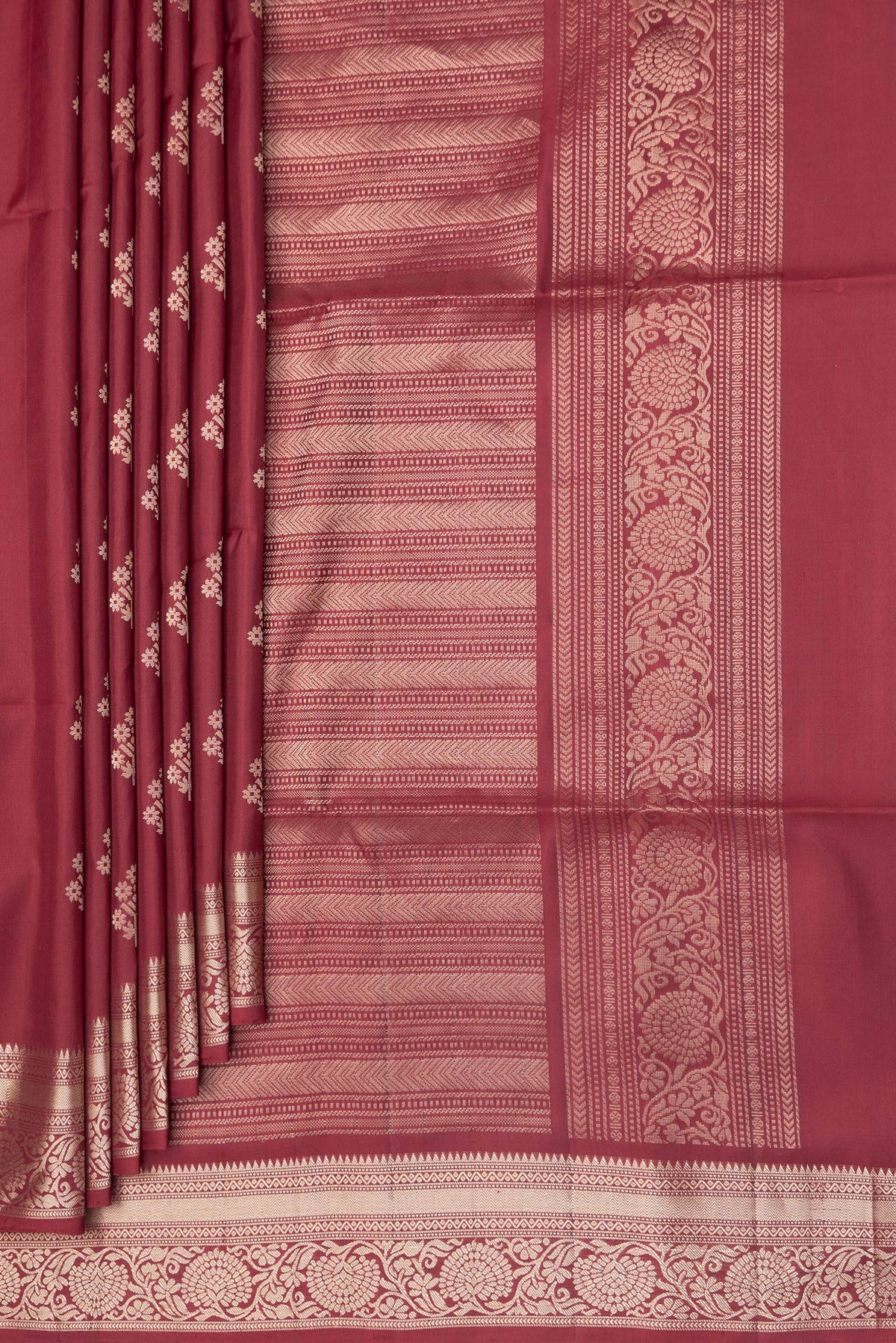 Pleats and pallu of Maroon Soft Silk Saree with Zari Butta on the body and Zari Border. 