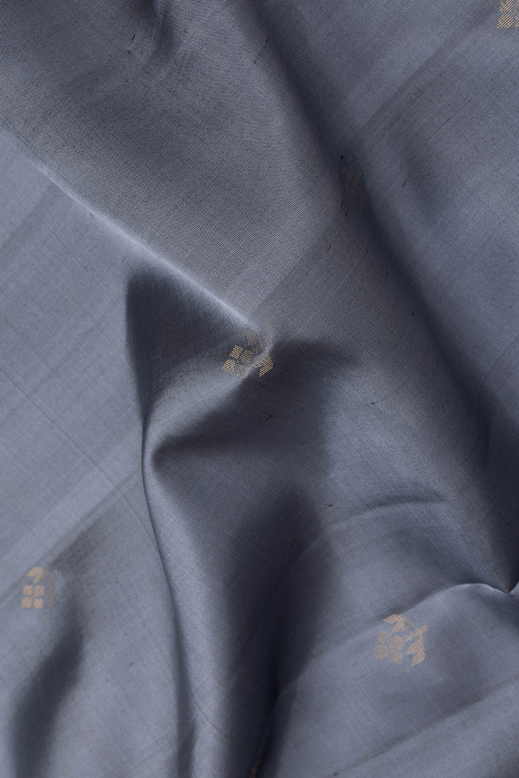 Close up of Grey Soft Silk Saree with Zari Butta on the body and Zari Border.  displaying folds