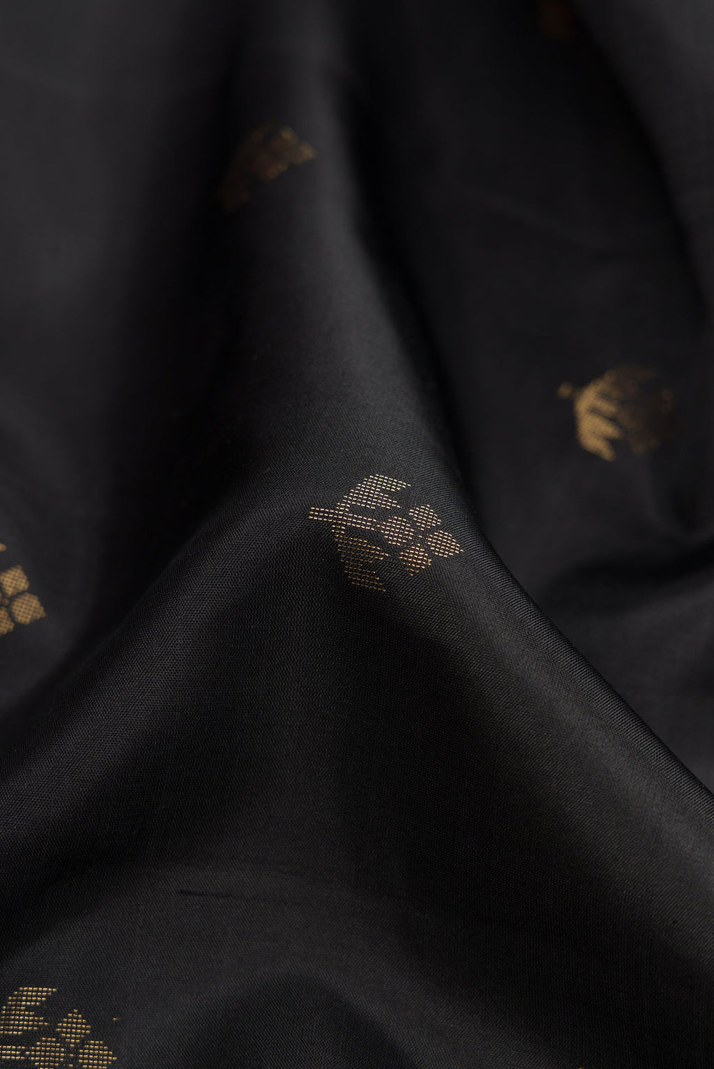 Close up of Black Dual Tone Soft Silk Saree with Zari Butta on the body and Zari Border.  displaying folds