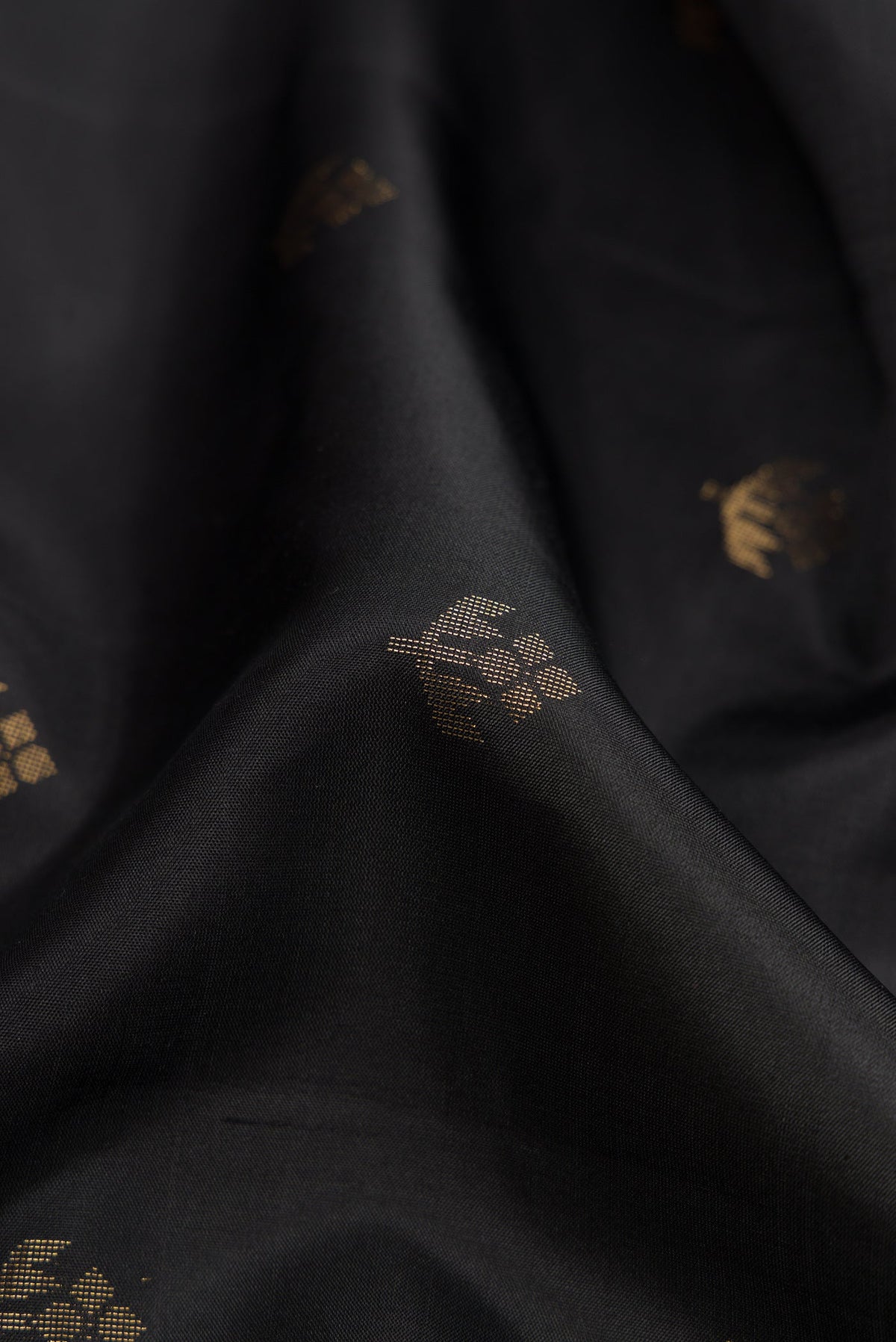 Close up of Black Dual Tone Soft Silk Saree with Zari Butta on the body and Zari Border.  displaying folds