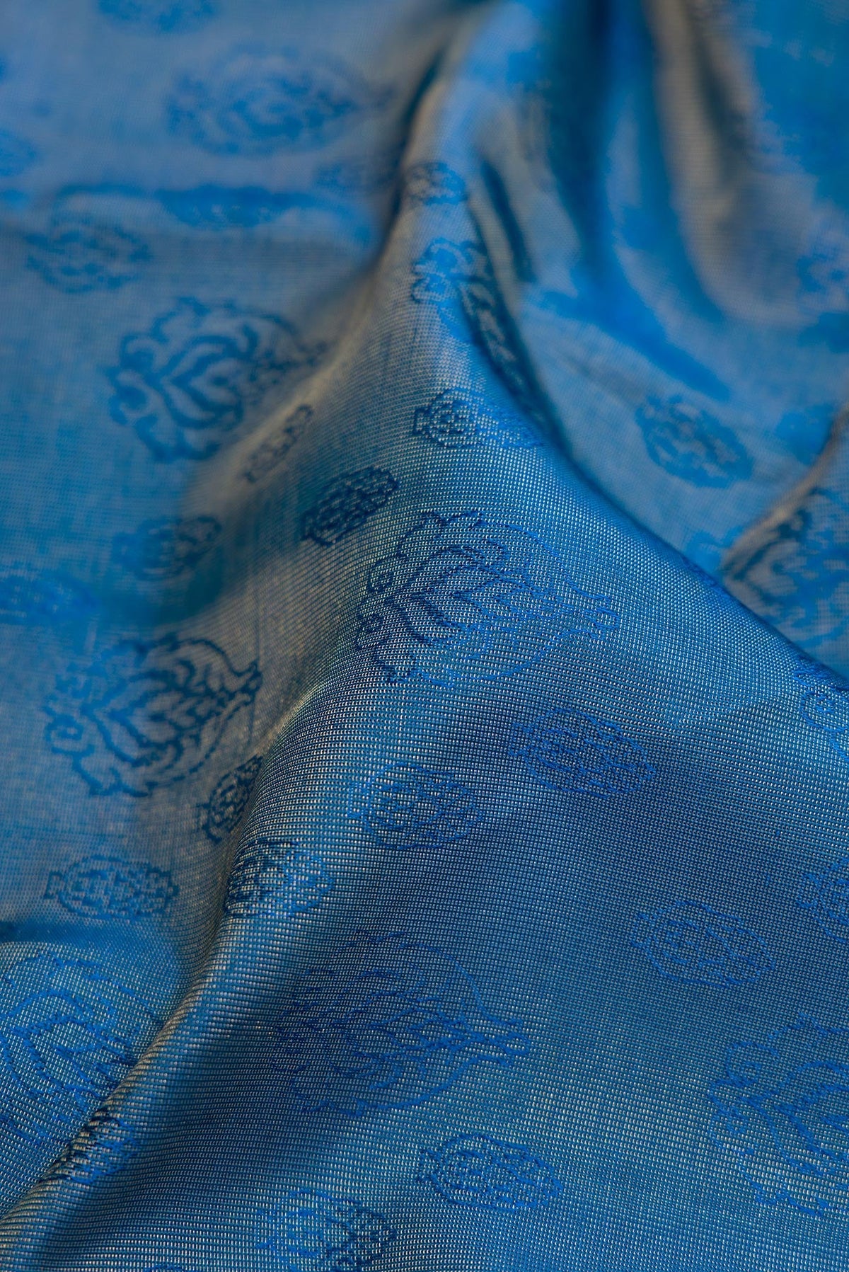 Close up of Maya Blue Dual Tone Kanchipuram Tissue Silk Saree with Zari Brocade on the body and Zari Border.  displaying folds