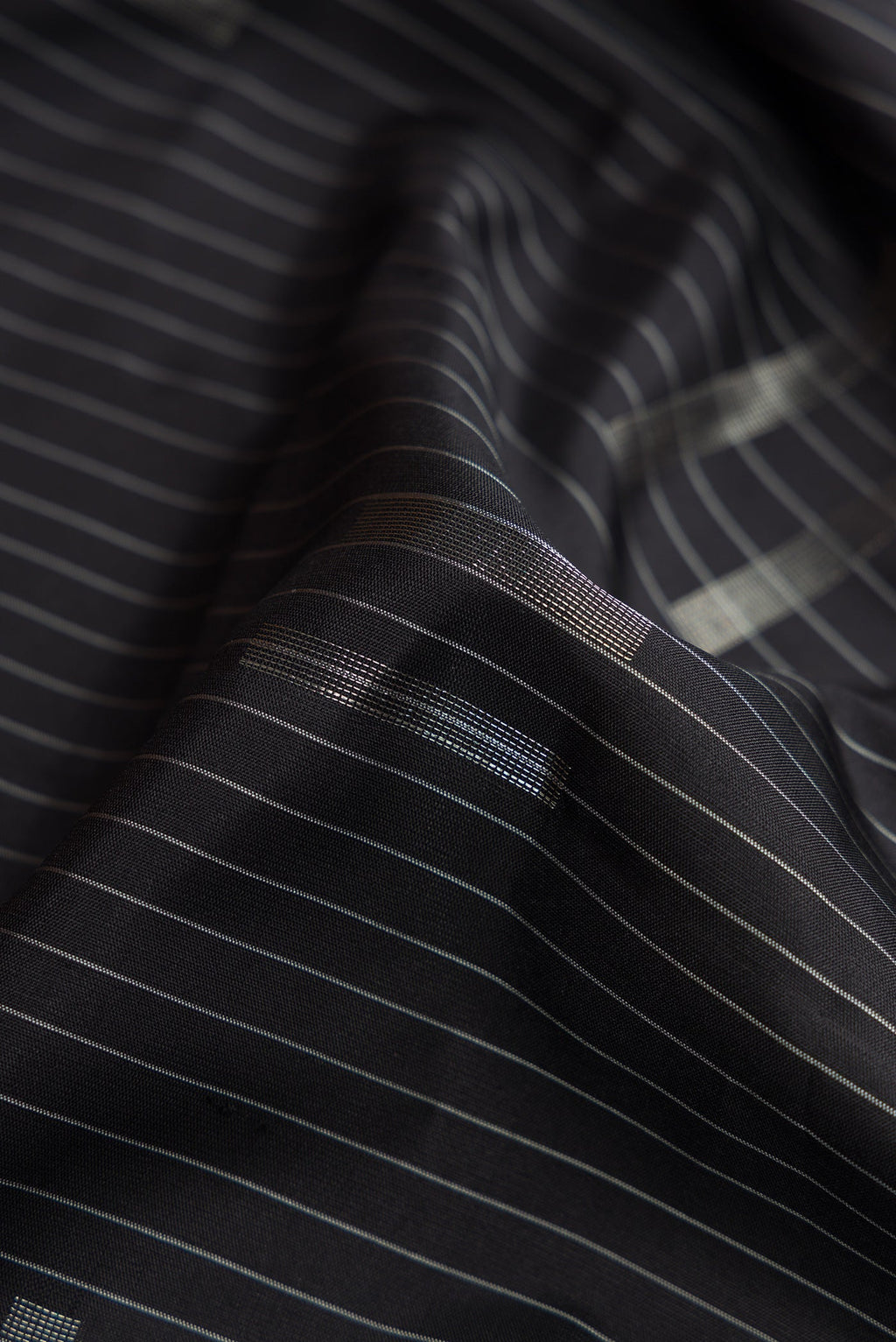 Close up of Black Dual Tone Soft Silk Saree with Stripes on the body and Zari Border.  displaying folds