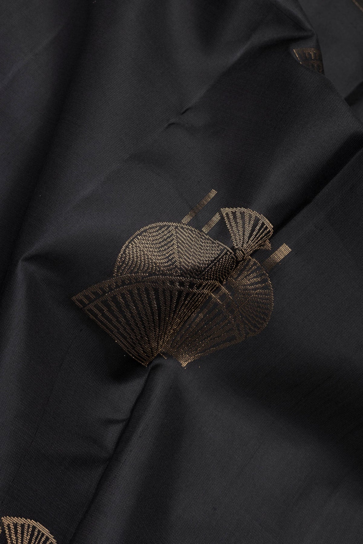 Close up of Black Soft Silk Saree with Zari Butta on the body and Without Border.  displaying folds